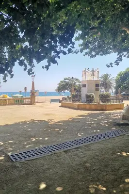 a view of a park with the ocean in the background at Apartamento centrico en Calella in Calella