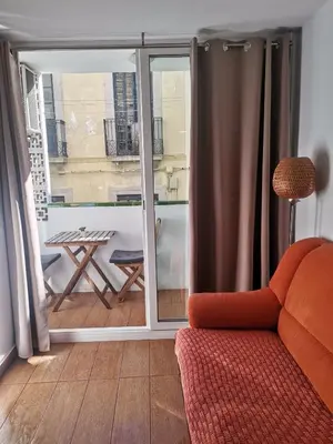 a room with a balcony with a table and a chair at Apartamento centrico en Calella in Calella