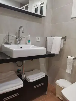 a bathroom with a sink and white towels at Apartamento centrico en Calella in Calella