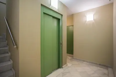 a green door in a hallway with stairs at Palau de la música 3 in Barcelona