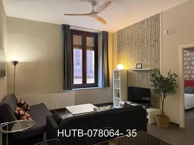 a living room with a couch and a ceiling fan at Palau de la música 4 in Barcelona