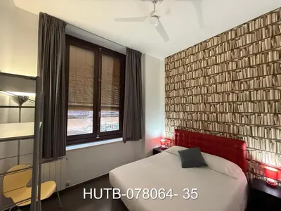 a bedroom with a bed with a red headboard and a window at Palau de la música 4 in Barcelona