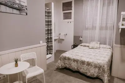 a bedroom with a bed and a table and chairs at Pensión 45 in Barcelona