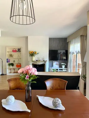 a dining room table with a vase of flowers on it at Villa Isabel Sitges, Rocamar in Sant Pere de Ribes