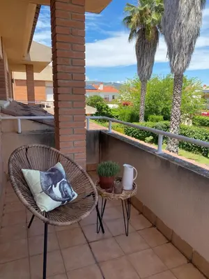 a bird pillow sitting on a chair on a patio at Villa Isabel Sitges, Rocamar in Sant Pere de Ribes