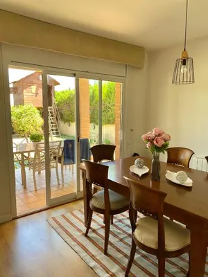 a dining room with a wooden table and chairs at Villa Isabel Sitges, Rocamar in Sant Pere de Ribes