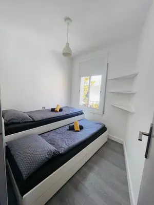 a bedroom with two beds and a window at Have Fun Apartment in Cubelles in Cubelles