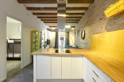 a kitchen with white cabinets and a brick wall at 64 Apartment in a typical Barcelona's old building in Barcelona