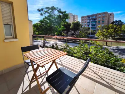 a wooden table and two chairs on a balcony at Casa en alquiler vacacional Vilanova i la Geltrú in Vilanova i la Geltrú