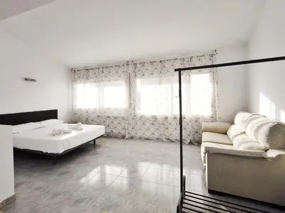 a white room with a bed and a couch at Casa en alquiler vacacional Vilanova i la Geltrú in Vilanova i la Geltrú