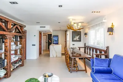 a living room with a blue couch and a table at Infinity Jupi Sea in Sitges