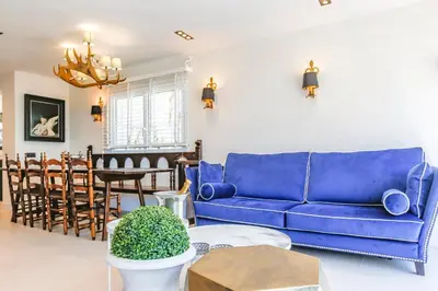 a living room with a blue couch and a table at Infinity Jupi Sea in Sitges