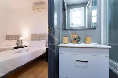 a bedroom with a bed and a sink and a mirror at Cosy apartment with terrace in Barcelona