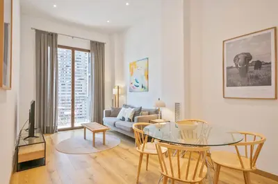 a living room with a glass table and a couch at Aspasios Arc de Triomf Apartments in Barcelona