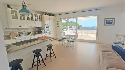 a kitchen and living room with a couch and a table at Casa Blanca in Sant Cebrià de Vallalta