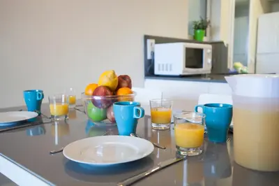 a table with glasses of orange juice and a bowl of fruit at BBarcelona Aragó Flat in Barcelona