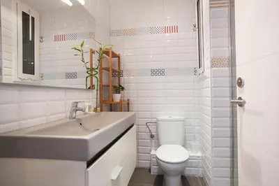 a white bathroom with a toilet and a sink at BBarcelona Aragó Flat in Barcelona