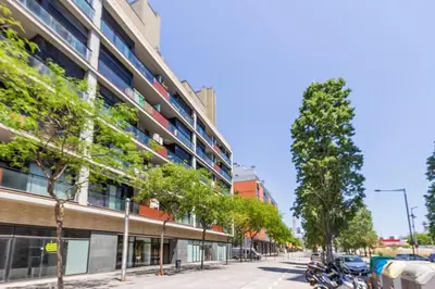 a tree lined street in front of a building at Piso en zona fòrum con vistas al mar in Barcelona