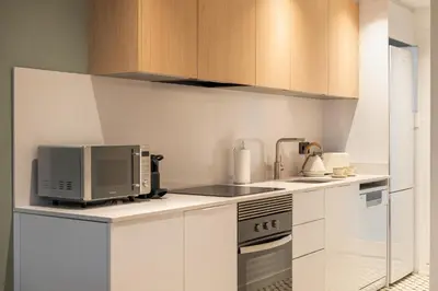a kitchen with white cabinets and a microwave at Stay U-nique Apartment Corsega II in Barcelona