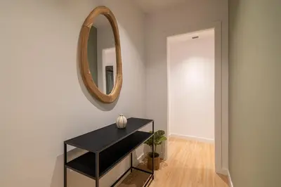 a hallway with a black table and a mirror at Stay U-nique Apartment Corsega II in Barcelona