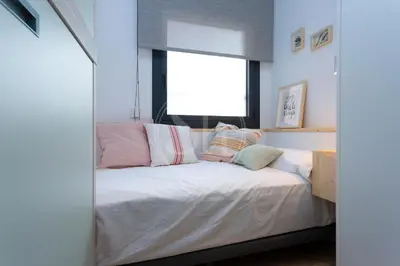 a bedroom with a bed with pink and white pillows at Maravilloso alojamiento con vistas a Barcelona in Barcelona
