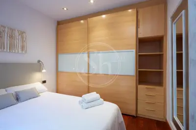 a bedroom with a white bed and a closet at Nice apartment in Les Corts in Barcelona