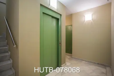 a green elevator door in a hallway with stairs at Palau de la música 8 in Barcelona