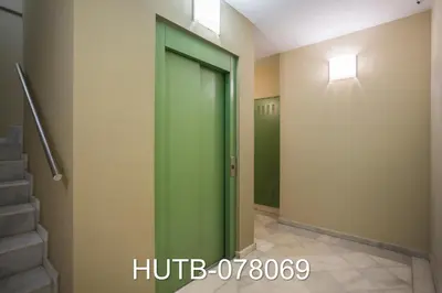 a green elevator door in a hallway with stairs at Palau de la música 9 in Barcelona