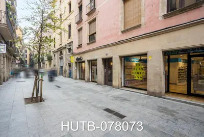 an empty city street with shops and buildings at Palau de la música 13 in Barcelona