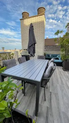 a wooden table and chairs on a patio at Spacious Penthouse with big private terrace & view in Barcelona