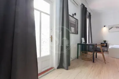 a room with a large window and a table at Céntrico apartamento familiar in Barcelona