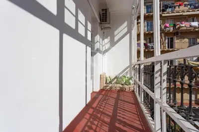 a balcony of a building with a shadow on the wall at Céntrico apartamento familiar in Barcelona