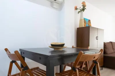 a bedroom with a white bed and a hallway at Practico apartamento con terraza en Eixample in Barcelona