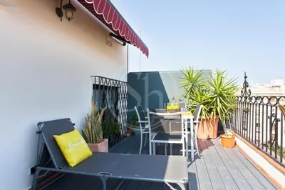 a patio with a table and chairs on a balcony at Cómodo apartamento para dos en el Eixample in Barcelona