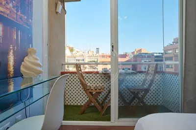 a balcony with two chairs and a glass table at Moderno Estudio en Eixample in Barcelona