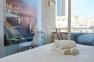 a hotel room with towels on a bed with a window at Moderno Estudio en Eixample in Barcelona