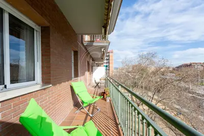 a balcony with green chairs on a brick building at Apartamento para 3 con balcón in Barcelona