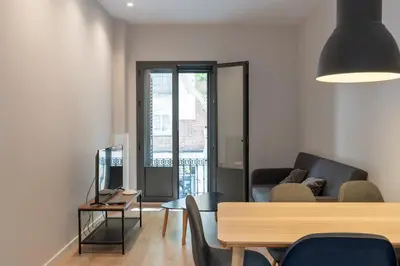 a living room with a couch and a television at Ola Living Gracia in Barcelona