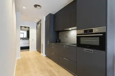 a kitchen with black cabinets and a stove at Ola Living Gracia in Barcelona