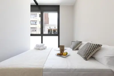 a bedroom with a large white bed with a window at Ola Living Gracia in Barcelona
