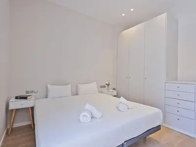 a white bedroom with a large white bed with two pillows at Ola Living Gracia in Barcelona