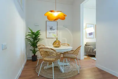 a dining room with a white table and chairs at Cómodo piso en Eixample in Barcelona
