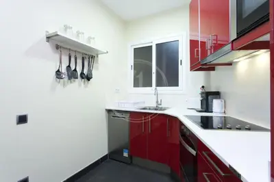 a kitchen with red cabinets and a sink at Apartamento en Sagrada Familia 2 in Barcelona