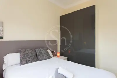 a bedroom with a white bed and a black wall at Apartamento en Sagrada Familia 2 in Barcelona