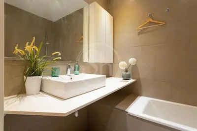 a bathroom with a white sink and a tub at Moderno apartamento familiar en Eixample in Barcelona