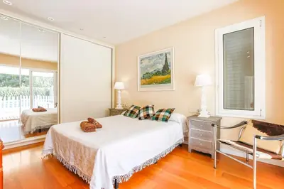 a bedroom with a bed and a chair in it at Villa Romady in Sant Pere de Ribes