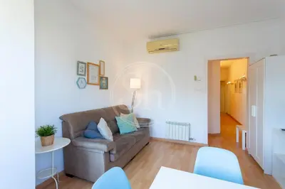 a living room with a couch and a table at Apartamento familiar en AvDiagonal in Barcelona
