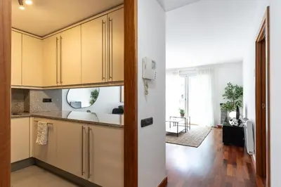 an open kitchen with yellow cabinets and a living room at Lovely apartment Sagrada Familia in Barcelona