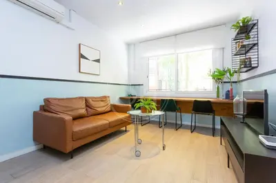 a living room with a couch and a table at Precioso apartamento en Les Corts in Barcelona