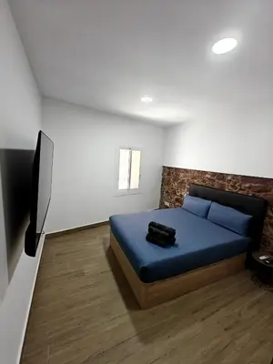a bedroom with a blue bed and a flat screen tv at Gorgeous Appartment in Martorell-Barcelona in Martorell